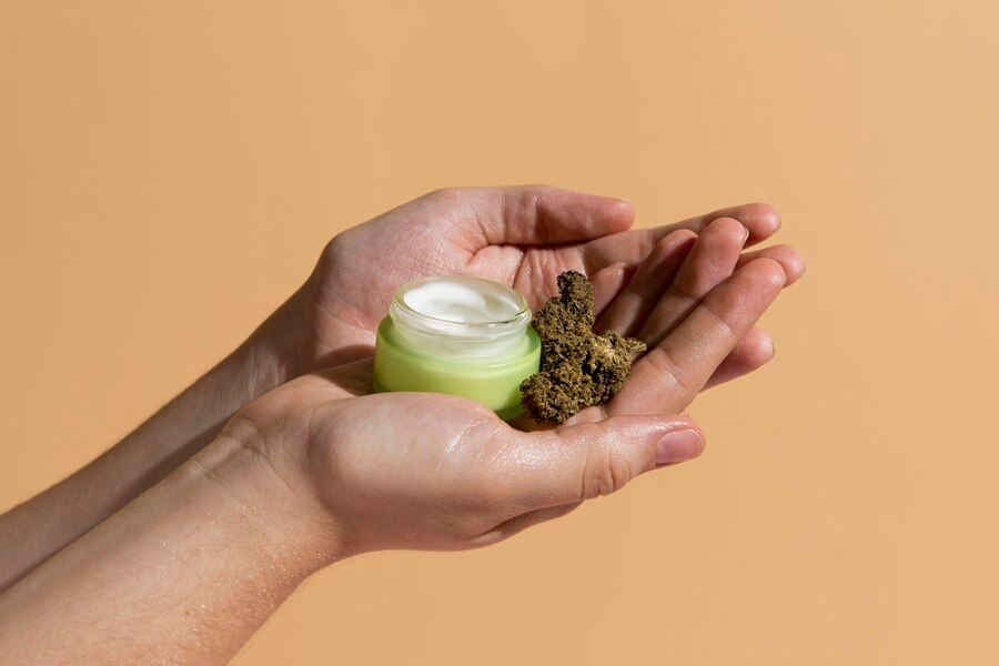 Jar of cream and dried cannabis